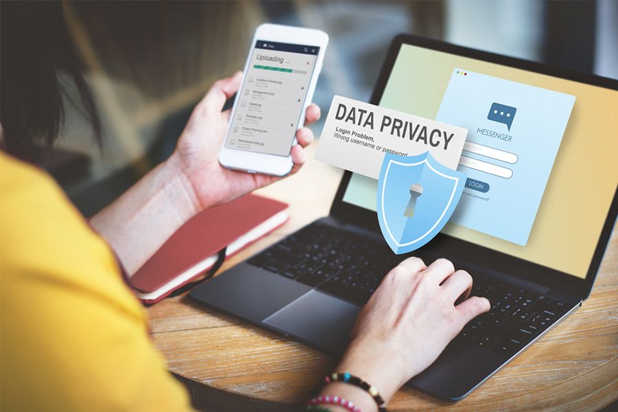 A person using a laptop and smartphone, both showing Wiperts.com's data privacy features.